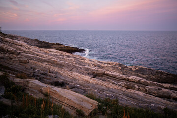 Amazing coastal sunset backdropping a historic lighthouse in Maine, USA. Near Arcadia National Park.