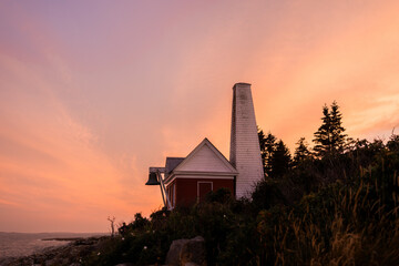 Amazing coastal sunset backdropping a historic lighthouse in Maine, USA. Near Arcadia National Park.