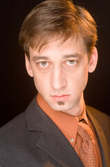 A man in a suit looking at the camera.
