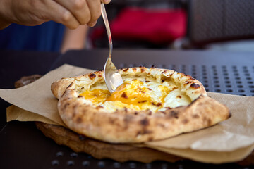 Serving Georgian khachapuri with melted cheese and egg