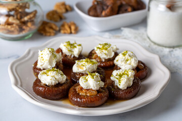 Stuffed dry fig dessert, cooked with syrup, traditional, pistachio and kaymak (Turkish name; kaymakli incir tatlisi )
