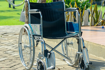 Silver Wheelchair with Black Seat Parked on Brick Path Outdoors