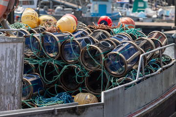 Fishing pots stacked on a boat deck with buoys and ropes © Azulblue