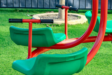 Colorful Playground Carousel Seats on Green Grass