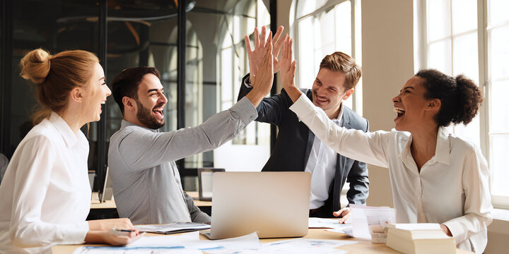business team working together in office giving high five