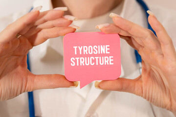 Notepad with the text and chemical structure of L Tyrosine on table with pills stethoscope.