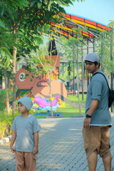 Father and Son Walking Together in Colorful Outdoor Park