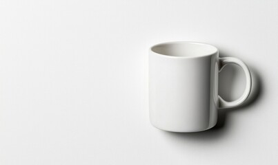 White ceramic mug angled to the right against a blank white surface. Simple, minimalist, and bright