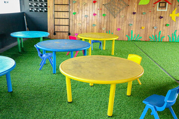 Colorful Round Tables with Chairs on Green Grass Playground