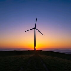 Obraz premium Silhouetted wind turbine at sunrise over a grassy hilltop.