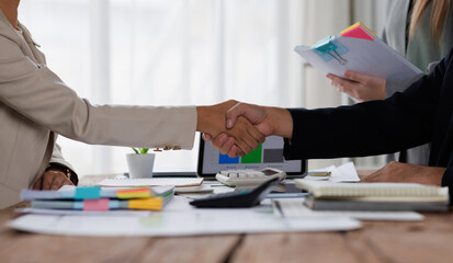 Happy financial advisor Banker and client shaking hands after business loan grant.