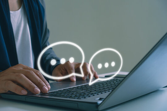 Close-up of hands typing on laptop keyboard with chat bubbles icon, representing online messaging, digital communication, customer service, social media interaction concepts. Online chatting support.