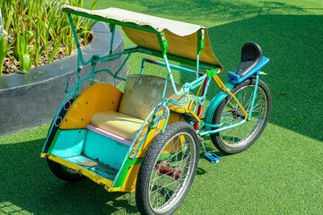 Colorful Tricycle Taxi on Green Artificial Grass Sunny Day