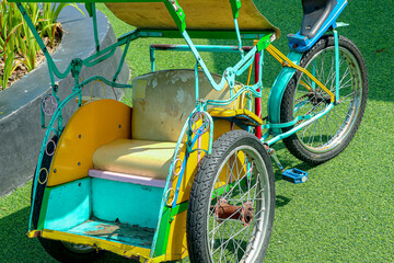 Naklejka premium Vintage Tricycle in Colorful Teal and Yellow on Green Lawn