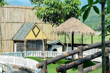 Cute Yellow Playhouse with Thatch Umbrella in Outdoor Setting