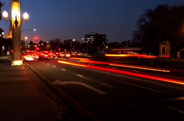 Abstract long exposure of city traffic at night with red car light trails and illuminated street...