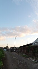 Obraz premium Urban Dirt Road with Old Buildings and Cloudy Sky During Daylight