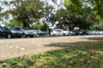 Cars parked outdoors under trees, blurred focus
