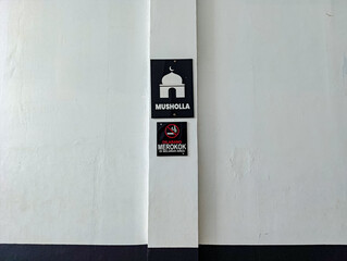 White Wall with Mosque Sign and No Smoking Sign