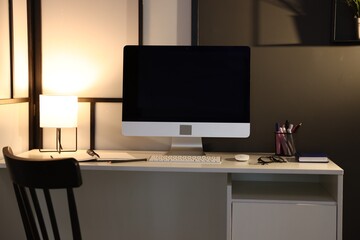 Desk with computer, stationery and glasses at home office. Interior design