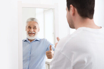 Man seeing himself as elder in mirror. Conceptual collage about past and future, flow of time, age