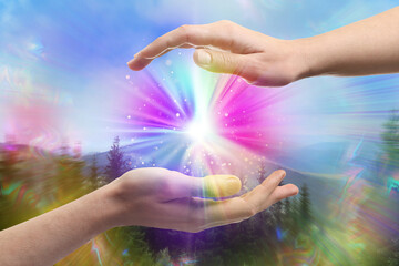 Man and woman creating bright light in mountains. Aura, spiritual practice