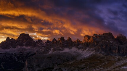 Golden peaks under a vibrant orange and purple sky, showcasing nature's majestic beauty.