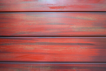 Close up of wooden wall panels painted in red color with visible natural grain texture, horizontal...