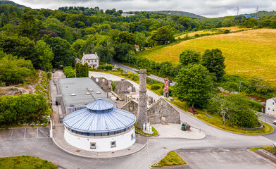 Aerial view of clay mining site in Cornwall with machinery, winding roads, and rural landscape...