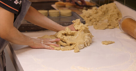 Baker preparing Welsh cakes in a bakery in Cardiff, Wales, kneading dough on a floured surface