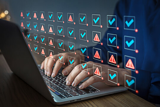 Man using laptop for online checklist with tick marks and error warnings for quality control