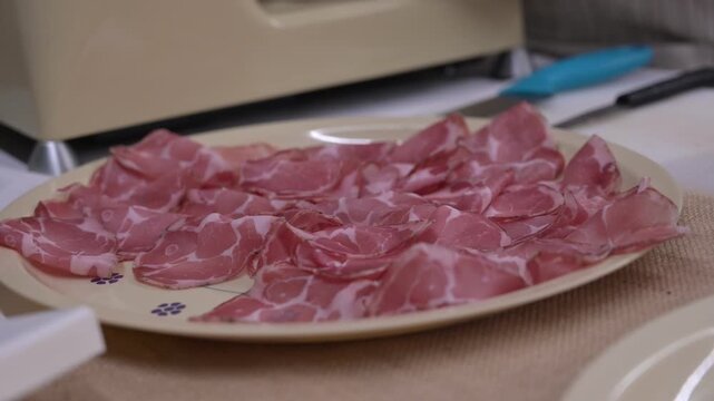 capocollo tagliato fresco con l'affettatrice in puglia