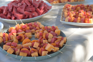 spiedini di frutta fresca serviti sul tavolo di un evento all'aperto in estate