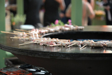 bocconcini di carne cucinati su di una brace circolare in un ristorante all'aperto