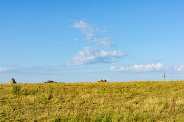 Fototapeta premium Grassy fields of St Benet's Abbey with remains of medieval structure and lonely cross