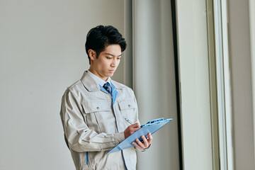 確認する作業服姿の男性