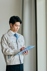 確認する作業服姿の男性