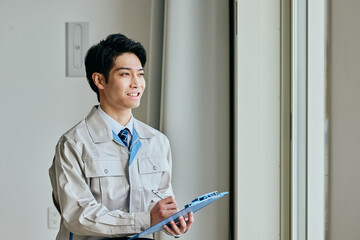 確認する作業服姿の男性