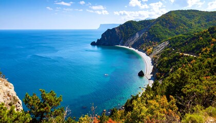 Fototapeta premium High angle view of a coastal bay with a beach and forested mountains.