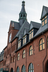Historic Red Brick Building with Clock Tower and Illuminated Windows
