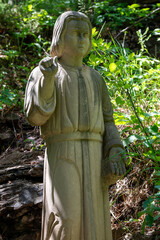 Stone Statue of Religious Figure in Forest Setting