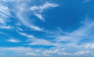 Obraz premium Blue sky with wispy cirrus clouds and small cumulus clouds below
