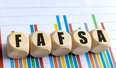 FAFSA acronym on wooden blocks with colorful bar chart in the background