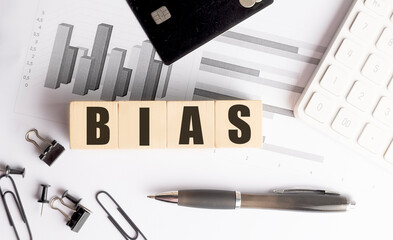 Bias word on wooden blocks with financial charts, calculator, pen and office supplies