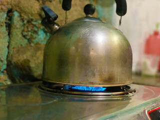 whistling kettle boiling water on the stove on fire