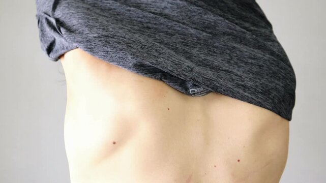 服を脱ぐ人物の後ろ姿の動画