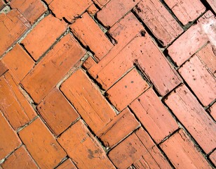 Herringbone arrangement of old red bricks forming a textured surface