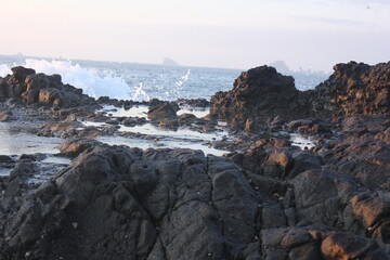 Rocky Shoreline with Blue Ocean and Distant Islands