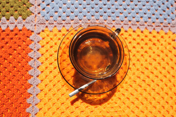 Warm cup of herbal tea on colorful crochet blanket
