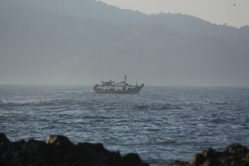 Fishing Boat at Sea with Misty Coastal Mountains